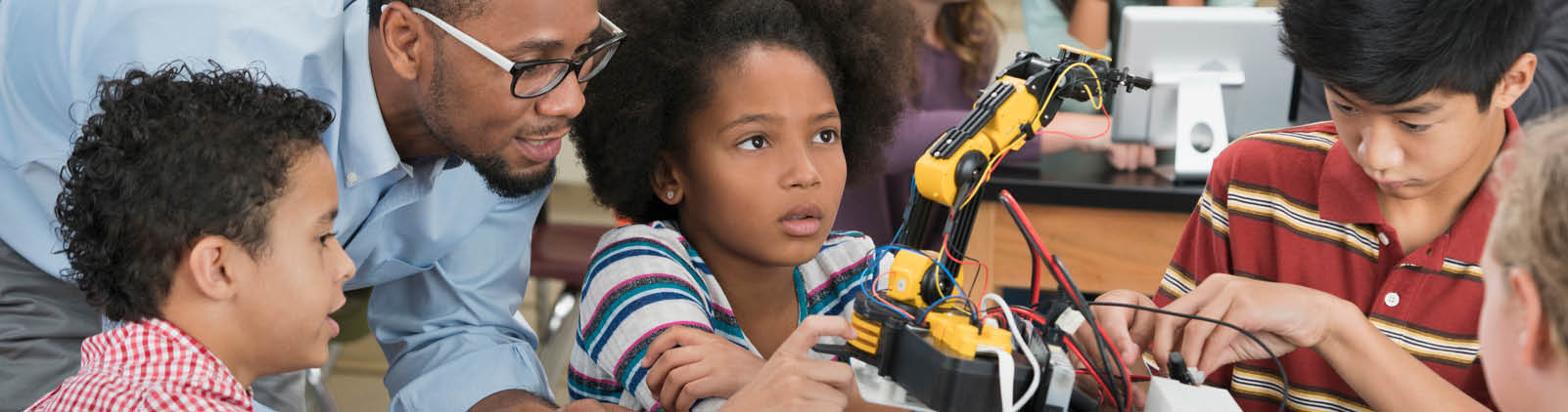 Teacher helping students in robotics class