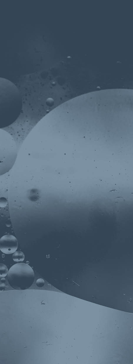 Close up macro image depicting droplets of oil in water on a multi colored background  The oil forms interesting circles and spheres in the water, and colorful background produces and abstract effect  Horizontal color image with copy space 