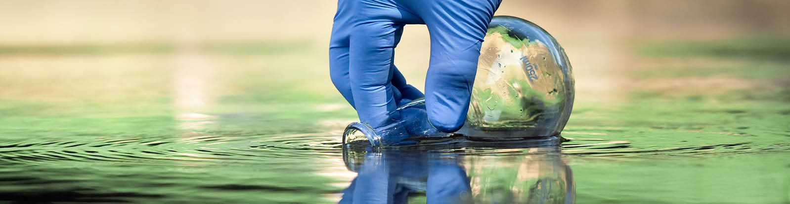 Water sample  Hand in glove collects water to explore  Concept - water purity analysis, environment, ecology  Water testing for infections, permission to swim