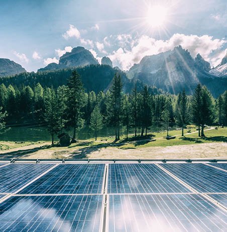 Solar cell panel in country landscape against sunny sky and mountain backgrounds  Solar power is the innovation for sustainability of world energy  Sustainable resources 