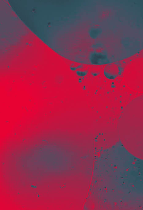 Close up macro image depicting droplets of oil in water on a multi colored background  The oil forms interesting circles and spheres in the water, and colorful background produces and abstract effect  Horizontal color image with copy space 