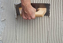 Construction notched trowel with white cement mortar for tiles work