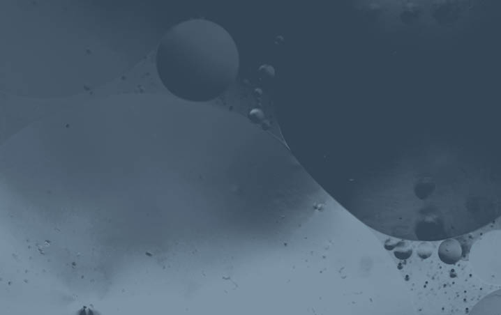 Close up macro image depicting droplets of oil in water on a multi colored background  The oil forms interesting circles and spheres in the water, and colorful background produces and abstract effect  Horizontal color image with copy space 