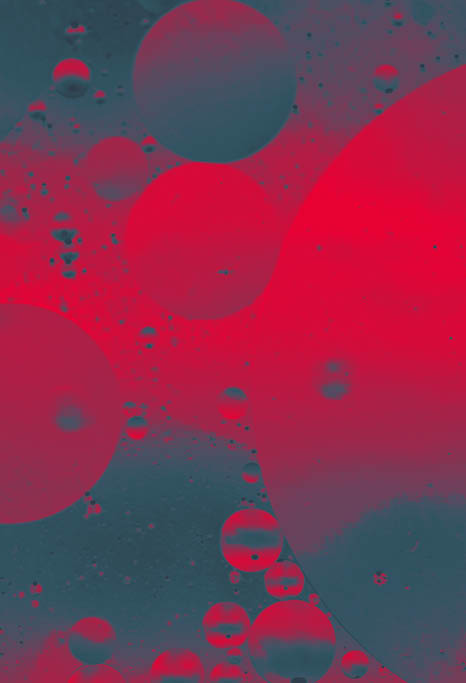 Close up macro image depicting droplets of oil in water on a multi colored background  The oil forms interesting circles and spheres in the water, and colorful background produces and abstract effect  Horizontal color image with copy space 